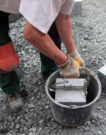 Dipping of a concrete block into STEIN TEC® Bond Adhesive "Haftfix".