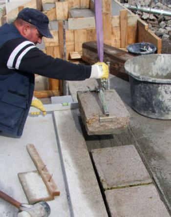Setting of a granite slab, dipped in STEIN TEC® Bond Adhesive “Haftfix”, into the mortar bed.